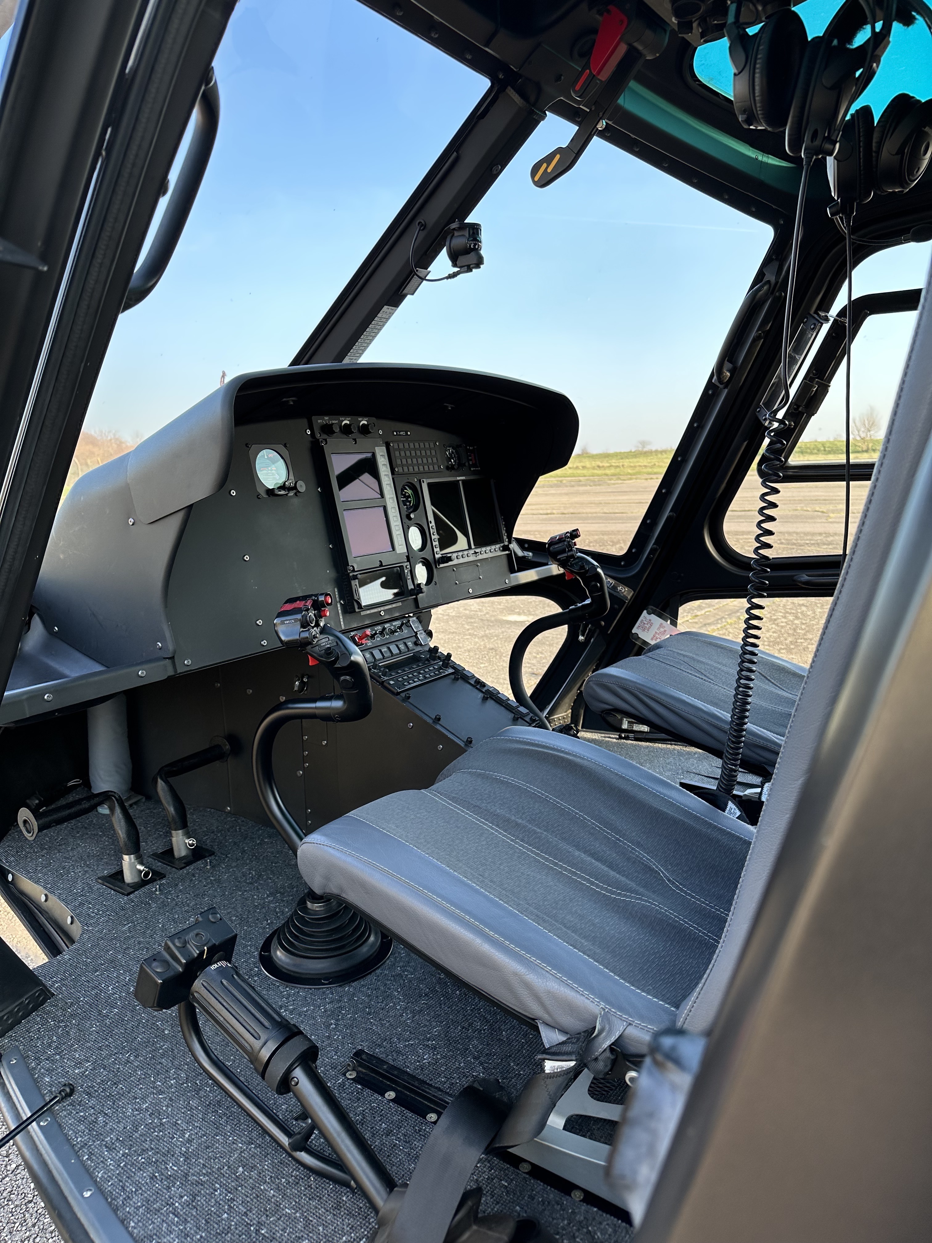 Helicopter cockpit instrument panel with various gauges and controls.